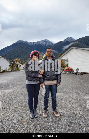 Des couples d'hommes et de femme portant des vêtements d'hiver se tenant devant snow mountain à matheson lake town ile sud Nouvelle zelande Banque D'Images