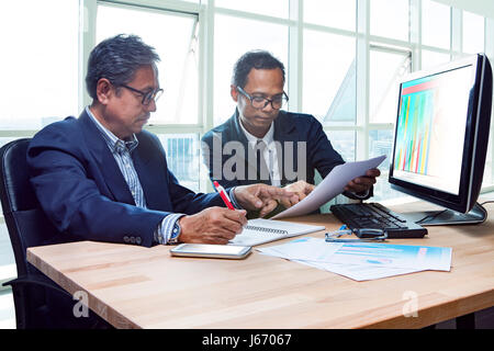 Partenaire de l'homme travail senior engineering réunion sérieuse au sujet de l'examen du projet de solution tourné sur le tableau de la salle de réunion du bureau Banque D'Images