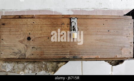 Boîte de bois cadenassé mis sur plateau céramique blanche sortant du mur d'un hangar utilisé comme location parking pour les gardiens locaux du ou Tham Jang Banque D'Images