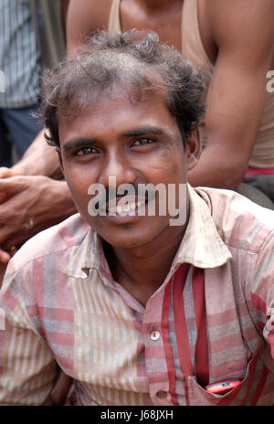 Conducteur de pousse-pousse indien posant assis sur tricycle rickshaw à Kolkata, en Inde le 10 février 2016. Banque D'Images