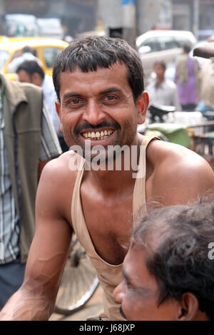 Conducteur de pousse-pousse indien posant assis sur tricycle rickshaw à Kolkata, en Inde le 10 février 2016. Banque D'Images