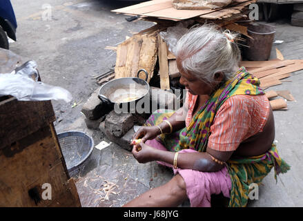 Une femme prépare la nourriture dans la rue, Kolkata, Inde le 10 février 2016. Banque D'Images