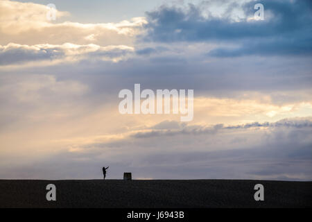 Plage de Chesil, Portland, Dorset, UK. 19 mai, 2017. Un homme prend un sur selfies Chesil Beach avec un fond cloudu orageux. Crédit : Dan Tucker/Alamy Live News Banque D'Images