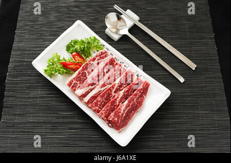 Tranches de boeuf au cumin et piment sur plateau blanc