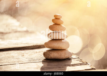 Pierres Spa still life sur la plage, pile de cailloux sur la promenade au-dessus de la mer dans le coucher du soleil la lumière, la paix et de détente en vacances, équilibre dans li Banque D'Images