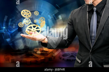 Internet des objets industriels 4.0 concept. Costume business man hand holding golden le rendu 3D'engrenages et de l'industrie graphique avec pignons abstrait backgroun Banque D'Images