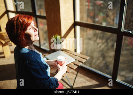 Heureux femme à boire profiter matin ensoleillé Banque D'Images