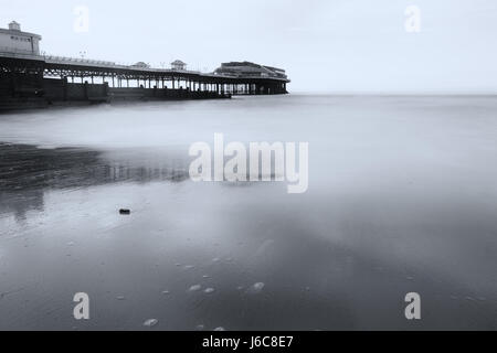 Marée basse à jetée de Cromer en noir et blanc avec une longue exposition à lisser les vagues et donner un sens à la photographie éthérée Banque D'Images