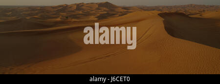 Vue du soleil en soirée sur de grandes dunes de sable rouge orangé collines paysage désertique étendue, Alpha Tours Desert Safari, Dubaï, Émirats arabes Unis Banque D'Images