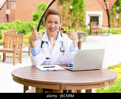 Closeup portrait jeune, souriant, confiant female doctor with stethoscope, professionnel de la santé giving Thumbs up fond isolé geste hospit Banque D'Images