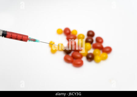 Concept d'OGM sur fond blanc avec les seringues et les tomates. Banque D'Images