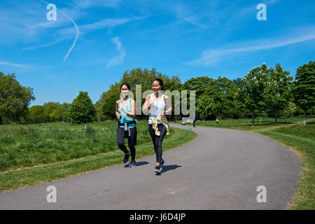 Deux jeunes femmes s'exécutant dans Regent's Park, Londres, Angleterre, Royaume-Uni, UK Banque D'Images