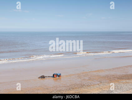 Un pêcheur le tracteur et remorque en attente sur plage de Cromer, Norfolk, UK Banque D'Images