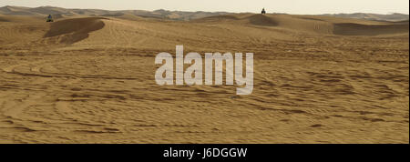 Sunny View dans le sable du désert avec des marques de roues à deux personnes passant en quad sur les dunes de sable, les Al Badayer, Dubai-Hatta Road, Dubaï, Emirats Arabes Unis Banque D'Images