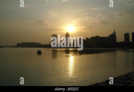 Vue sur les eaux calcaires de Mina Seyahi Beach Resort, de Al Sufouh Road, au lever du soleil au-dessus de Arjaan Office Building, Dubaï, Émirats arabes Unis Banque D'Images