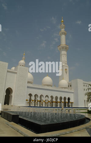 Ciel bleu de l'eau portrait-fontaine en face de dômes, arches et minaret. angle nord-est la grande mosquée Sheikh Zayed, Abu Dhabi, Émirats arabes unis Banque D'Images