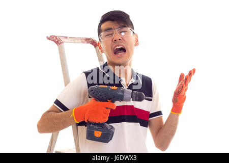 Young man holding tournevis électrique et assis sur ledder Banque D'Images