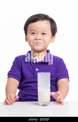 Adorable bébé garçon avec lait potable avec du lait moustache holding verre de lait Banque D'Images