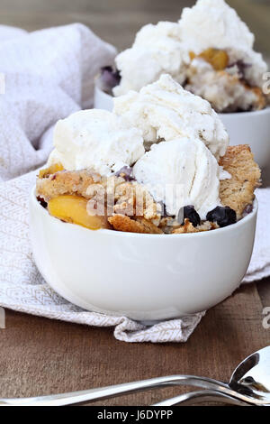 Fresh peach cobbler aux bleuets et servi avec de la glace à la vanille. Profondeur de champ avec focus sélectif. Banque D'Images