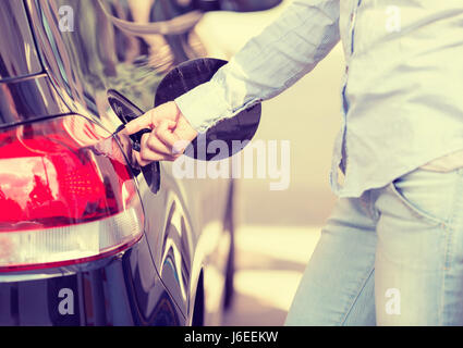 Femme de gaz de voiture d'ouverture au bouchon du réservoir à essence Banque D'Images