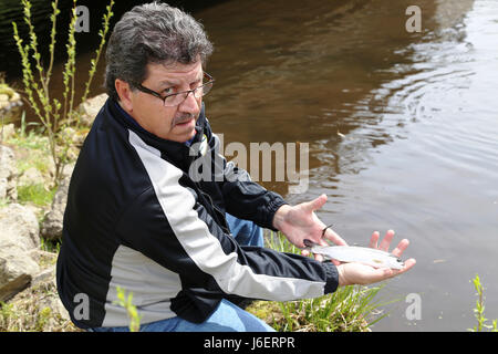 John Noble, biologiste des pêches à la Direction des travaux publics de la Division de l'environnement des ressources naturelles, est titulaire d'une truite arc-en-stock dans Suukjak Sep Lake près de Pine View Campground le 25 avril 2017, à Fort McCoy, Wisconsin (Etats-Unis) au cours de deux semaines à la fin d'avril, le personnel avec le U.S. Fish and Wildlife Service, Station piscicole de Gênes Gênes, au Wisconsin, a planté plus de 15 000 truites arc-en-ciel dans les cours d'eau Fort McCoy en préparation de la saison de pêche 2017. (U.S. Photo de l'Armée de Scott T. Sturkol, Public Affairs Office, Fort McCoy, Wisconsin) Banque D'Images