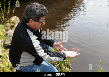 John Noble, biologiste des pêches à la Direction des travaux publics de la Division de l'environnement des ressources naturelles, est titulaire d'une truite arc-en-stock dans Suukjak Sep Lake près de Pine View Campground le 25 avril 2017, à Fort McCoy, Wisconsin (Etats-Unis) au cours de deux semaines à la fin d'avril, le personnel avec le U.S. Fish and Wildlife Service, Station piscicole de Gênes Gênes, au Wisconsin, a planté plus de 15 000 truites arc-en-ciel dans les cours d'eau Fort McCoy en préparation de la saison de pêche 2017. (U.S. Photo de l'Armée de Scott T. Sturkol, Public Affairs Office, Fort McCoy, Wisconsin) Banque D'Images