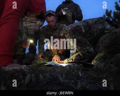 1er lieutenant Kevin Parker de Mustang, Oklahoma soldats aéroportés d'Ukrainien vérifie la carte des parcelles au cours de la navigation terrestre de la formation au 1er Bataillon, 95e Brigade Mobile Air Domaine de formation, Zhytomyr, Ukraine, 05 mai 2017. Sous le mentorat de Group-Ukraine multinational interarmées, actuellement dirigé par l'armée américaine 45th Infantry Brigade Combat Team, le militaire ukrainien tente d'établir une interopérabilité OTAN Centre d'instruction au combat en 2020. (Photo de 1er Lieutenant Rob Hughes, 45th Infantry Brigade Combat Team) Banque D'Images