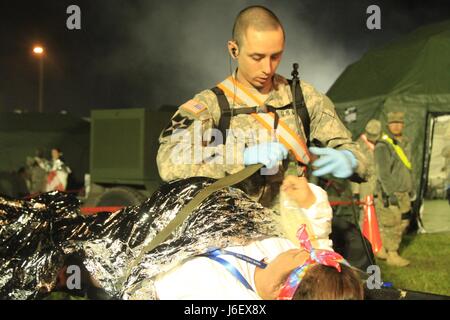 Le Sgt. Michael Ciske, infirmier de la 409ème Compagnie médicale de soutien de secteur (ASMC), obtiendra un patient à une civière pour le transport par ambulance à l'attente Muscatatuck Urban Training Center à Butlerville Ind., la 409ème de l'ASMC, basé à Madison, Wisconsin, a été parmi les 75 unités qui ont pris part à un tuteur, 17 Réponse d'un exercice d'entraînement multi-composants conçus pour tester la capacité des unités de l'armée américaine pour soutenir l'appui de la défense aux autorités civiles (DSCA) dans le cas d'un produit chimique, biologique, radiologique et nucléaire (CBRN) catastrophe. (Photo de 1er Sgt. Angele Ringo) Banque D'Images