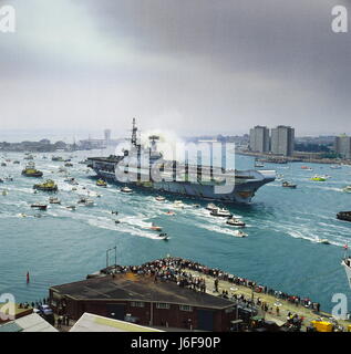 AJAXNETPHOTO. Juillet 21st, 1982. PORTSMOUTH, ANGLETERRE - RETOURS - LE PORTE-AVIONS HERMES RETOUR À PORTSMOUTH ACCOMPAGNÉ D'une flottille de sympathisants À LA FIN DE SON DEVOIR DE L'ATLANTIQUE SUD AU COURS DE LA CAMPAGNE des Malouines. REF:820721 3 2 Photo:JONATHAN EASTLAND/AJAX. Banque D'Images