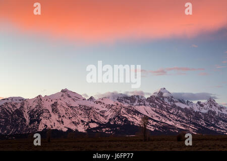 Un grand nuage éclairé avec lumière coucher de planer au-dessus des montagnes Teton. Parc National de Grand Teton, Wyoming Banque D'Images