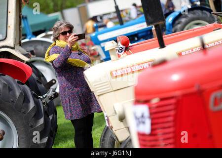 Royal Welsh Festival du printemps, Builth Wells, Powys, Wales - Mai 2017 - Une femme visiteur prend une photo de l'ancien tracteur vintage expose au Royal Welsh Spring Festival tenu au milieu du Pays de Galles. Photo Steven Mai / Alamy Live News Banque D'Images