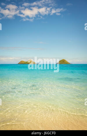 L'eau cristalline et turquoise des eaux vert émeraude Plage Lanikai sur un jour d'été chaud et ensoleillé sur Oahu, Hawaii. Banque D'Images