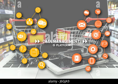 La plate-forme de gestion des données (DMP) , Marketing et crm concept. L'infographie , textes et icônes avec deux caddies sur smart phone et l'ordinateur portable dans la vente au détail Banque D'Images