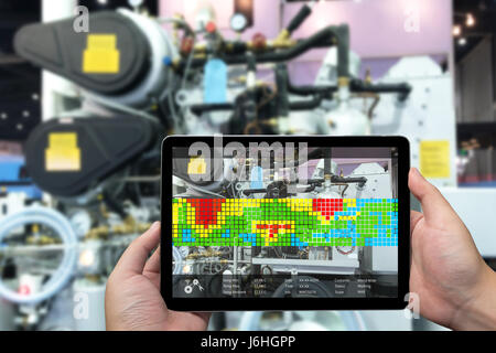 Marketing de la réalité augmentée et de l'industrie 4.0 concept. Main tenant tablette avec écran AR demande de température de la mesure de la machine en fait intelligente Banque D'Images