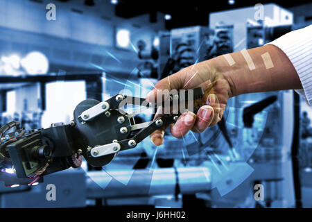 Communication et concepts robotique cybernétique. 4.0 Systèmes industriels Cyber concept physique. Robot et humain Engineerer holding hand avec poignée de main et gr Banque D'Images