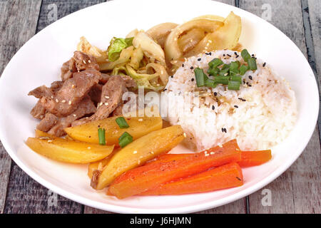 Riz au jasmin thaï dans American style coréen, du riz avec des tranches de steak de porc, des tranches de pommes de terre,carottes,l'oignon et le chou frit garni sesames et l'échalote. Banque D'Images