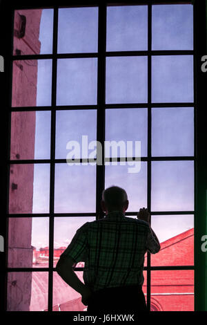 Italie.57e Biennale de Venise, la Biennale di Venezia 2017 homme regarde par la fenêtre du pavillon de l'Afrique du Sud.Senior man standing at window Banque D'Images