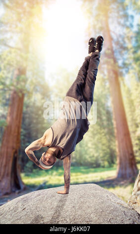 Breakdance interprète, à l'envers motion dans la forêt. Style de danse moderne. Danseur Banque D'Images