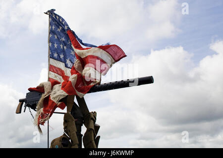 Drapeau américain endommagé enroulée autour d'une Machine Gun Banque D'Images