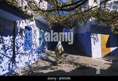 18.11.2010, Chefchaouen, Maroc, Afrique - une femme entre dans le dédale de ruelles et de passé de couleur bleu-blanc façades à Chefchaouen. Banque D'Images