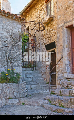 Les anciennes maisons en pierre d'eze décorées de fleurs, et plantes en pots, en France. Banque D'Images