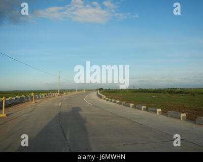 Cette image montre des rizières le long des routes du Salapungan à Magumbali Paralaya Poblacion, Candaba, Pampanga. Les champs luxuriants soulignent l'importance agricole de la région dans la production de riz et les pratiques agricoles dans la région. Banque D'Images