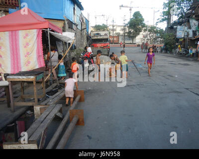 Une vue au niveau de la rue des barangays Pier 18 et Marcos Road à Tondo, Manille, avec le paysage urbain et commercial de ce quartier animé de la capitale. L'image met en évidence les routes clés et la vie urbaine au cœur de Manille. Banque D'Images