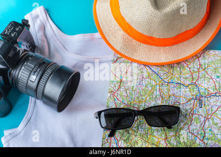 Kit de voyage : un chapeau, un appareil photo, la carte, t-shirt et lunettes de soleil. Mise à plat d'une composition pour les médias sociaux et d'affaires. Vue aérienne Banque D'Images