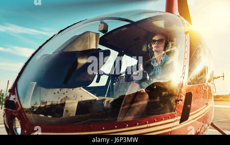 Jolie femme pilote assis dans l'hélicoptère Banque D'Images