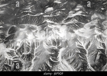 Les jeunes montagnes au printemps. Panorama d'oiseau sur les pentes et les sommets de rupture de la neige. Des champs de neige et la ramification des gorges. Dans la technique de dessin sur ordinateur Banque D'Images