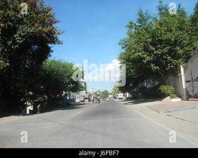Cette image montre la route nationale Candaba Santa Ana à Pasig, avec un ponceau situé près de Pansul, Pampanga. L'infrastructure routière est un élément essentiel du transport local, assurant l'efficacité de l'écoulement de l'eau et la stabilité des routes. Banque D'Images