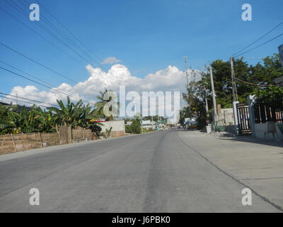 L'image montre la route nationale Candaba Santa Ana à Pasig, Pampanga. Cette route sert de lien de transport important entre les régions clés de la province, facilitant la circulation des personnes et des marchandises. Il souligne l'importance des routes nationales pour la connectivité économique et sociale. Banque D'Images