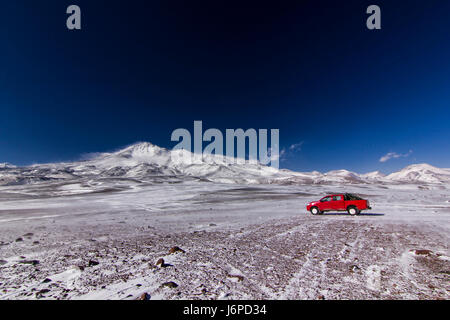 Voiture rouge près de volcan Ojos del Salado au chili Banque D'Images