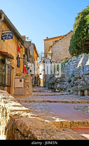 EZE, FRANCE - 23 février 2012 : l'étroite rue Paix vallonné avec magasins et cafés touristiques, situé dans la ville médiévale de maisons en pierre, le 23 février à Eze. Banque D'Images